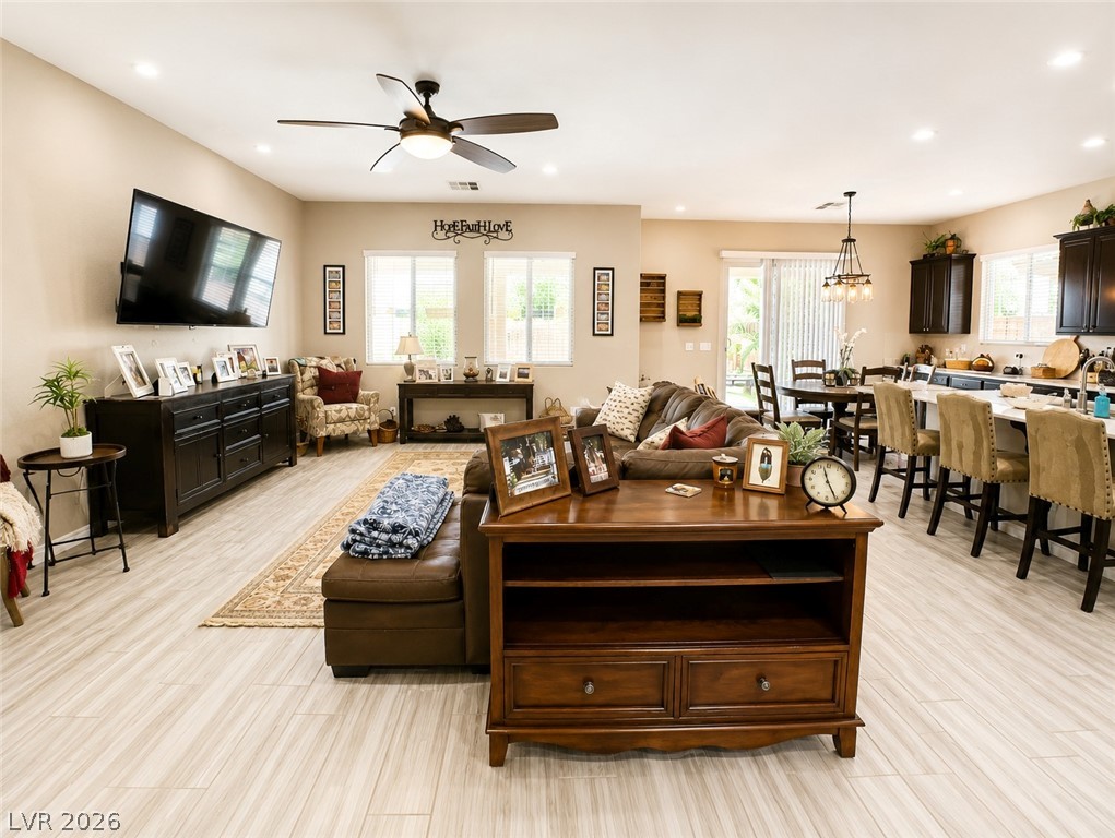 9724 University Ridge Avenue Las Vegas, NV 89149 - Photo 6 of 61 An open concept living and dining area with clean lines, featuring a functional kitchen island and bright natural light.