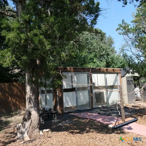 a view of a house with backyard and trees