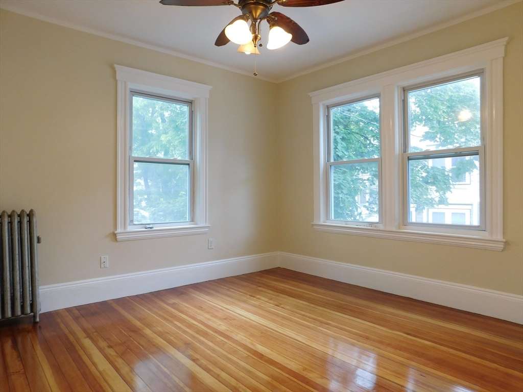 17 Manley Street, Unit 2 Boston, MA 02122 - Photo 4 of 16 a view of an empty room with wooden floor and a window