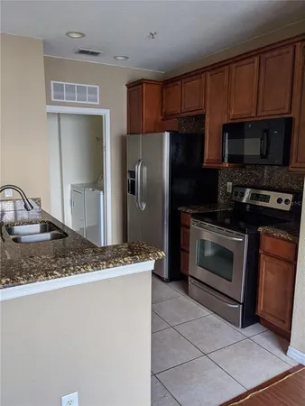 a kitchen with stainless steel appliances granite countertop a stove a refrigerator and a sink