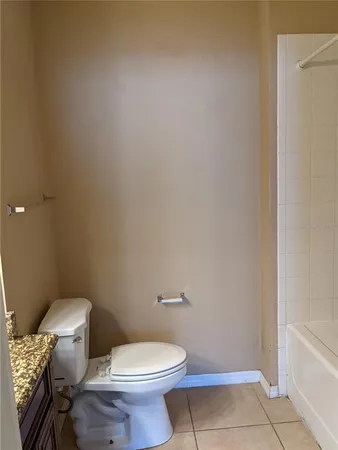 a white toilet sitting next to a bath tub