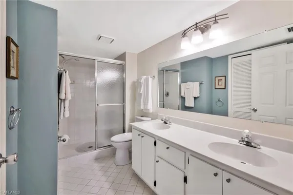 a bathroom with a double vanity sink mirror double and shower