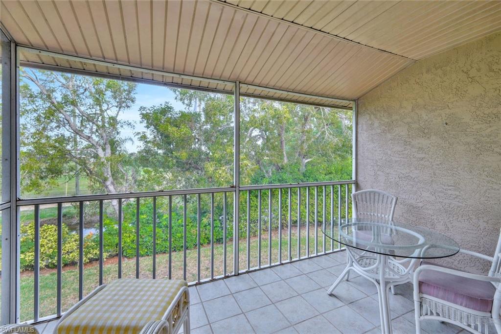 234 Pebble Beach Boulevard, Unit 306 Naples, FL 34113 - Photo 4 of 19 a view of a balcony with chair and white wooden fence