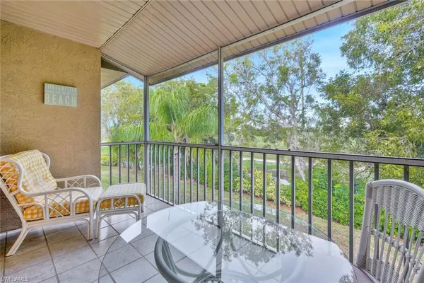 a balcony with chairs and table