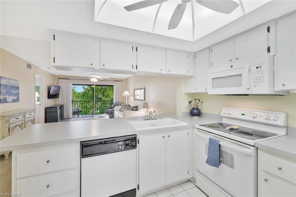 234 Pebble Beach Boulevard, Unit 306 Naples, FL 34113 - Photo 10 of 19 a kitchen with cabinets appliances a sink and a counter top space