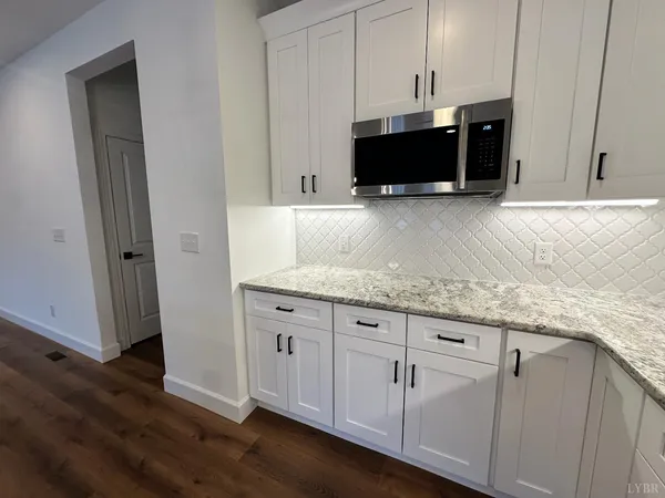 a kitchen with white cabinets and sink