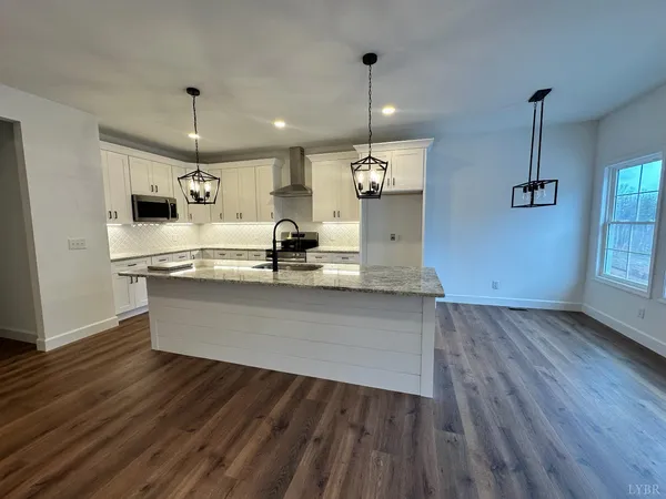 a kitchen with granite countertop white cabinets and a stove