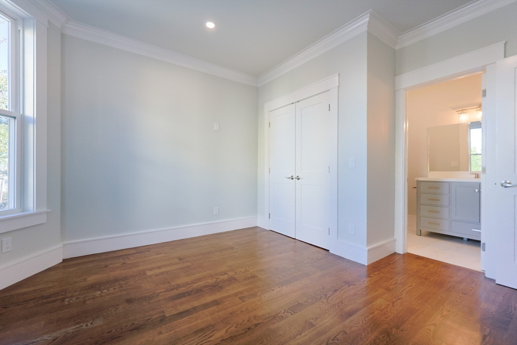 19 Fenwick Street, Unit 4 Somerville, MA 02145 - Photo 18 of 33 an empty room with wooden floor and windows