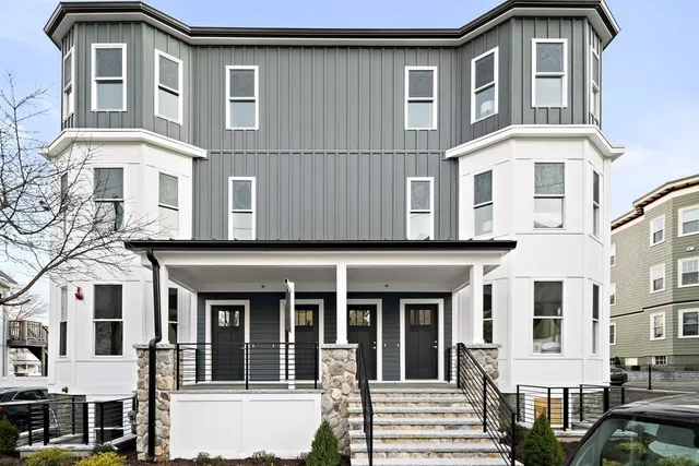 a front view of a residential apartment building with a yard