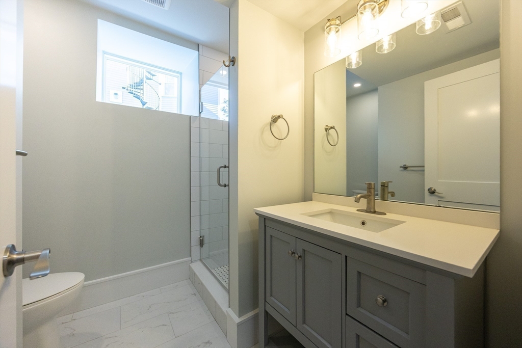 19 Fenwick Street, Unit 4 Somerville, MA 02145 - Photo 28 of 33 a bathroom with a sink a toilet and a mirror