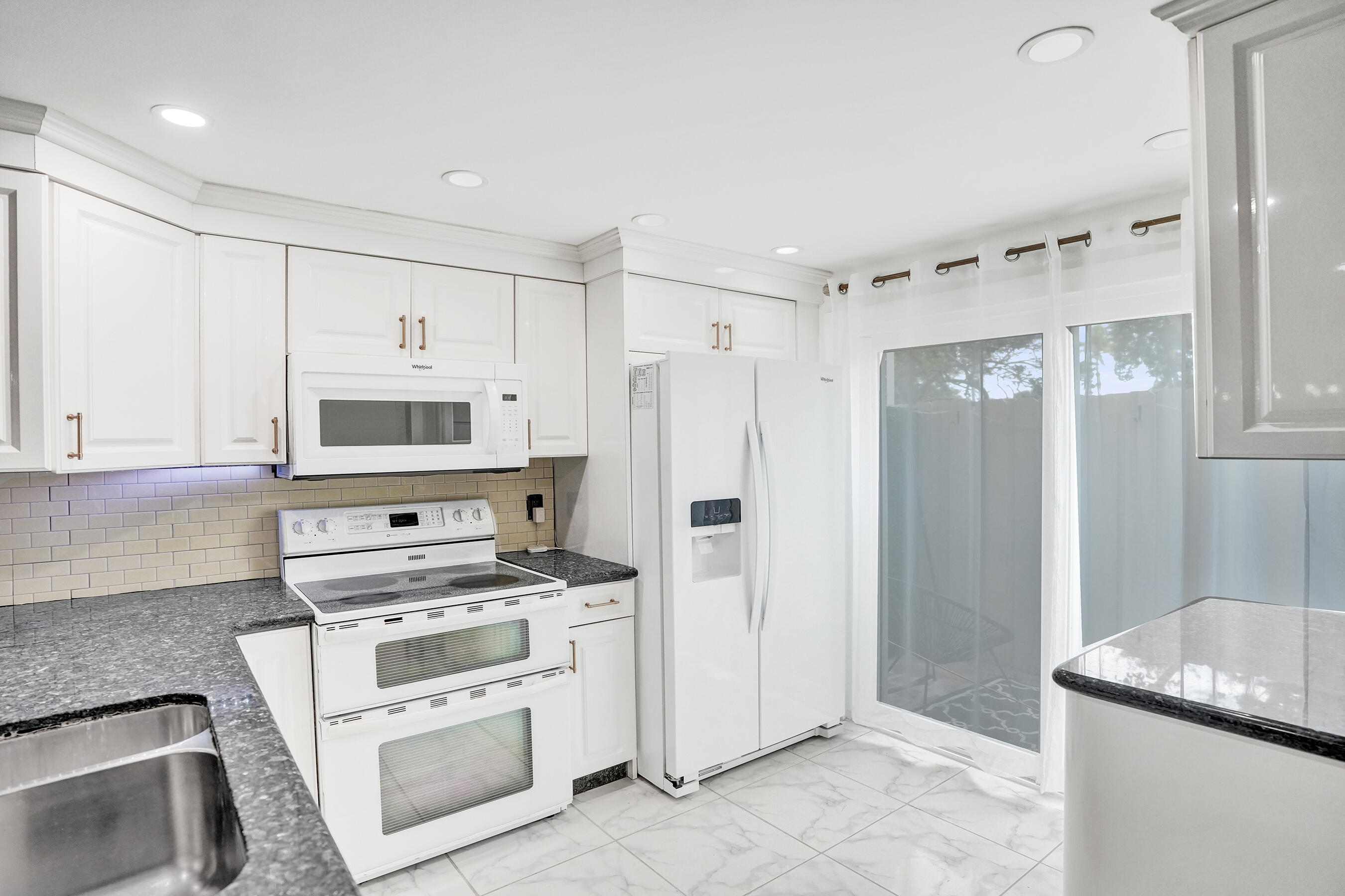 147 Southwest 3rd Street Pompano Beach, FL 33060 - Photo 6 of 29 a kitchen with white cabinets and white appliances