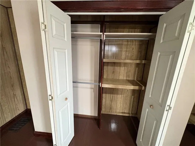 a view of walk in closet with wooden floor