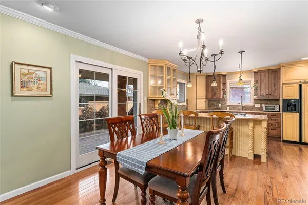 a view of a dining room with furniture a chandelier and wooden floor
