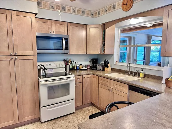 a kitchen with a sink and a stove top oven with wooden floor