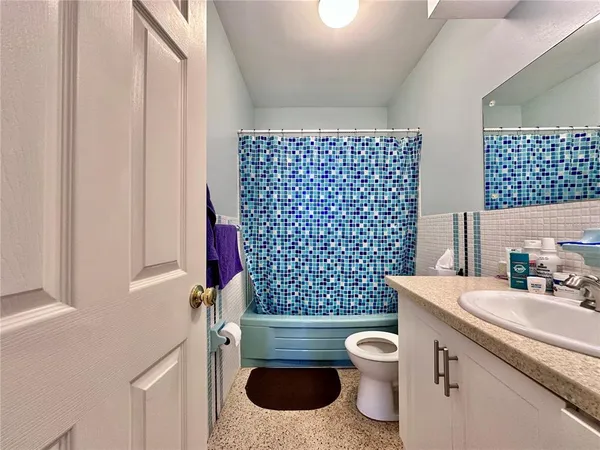 a bathroom with a granite countertop toilet a sink and a mirror