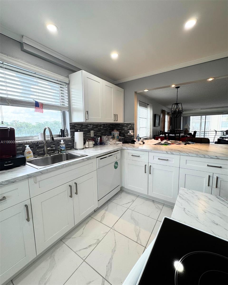 3776 Inverrary Boulevard, Unit 301R Lauderhill, FL 33319 - Photo 27 of 31 a kitchen with white cabinets sink and white appliances
