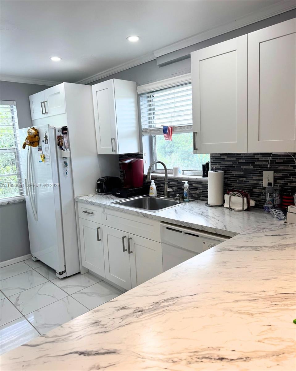 3776 Inverrary Boulevard, Unit 301R Lauderhill, FL 33319 - Photo 4 of 31 a kitchen with stainless steel appliances kitchen island granite countertop a refrigerator and a sink