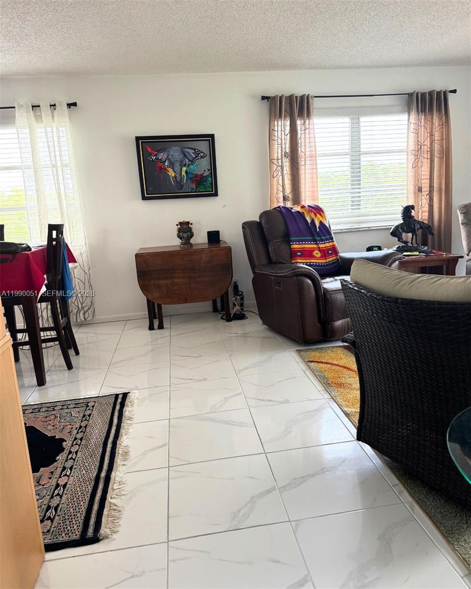 3776 Inverrary Boulevard, Unit 301R Lauderhill, FL 33319 - Photo 8 of 31 a living room with furniture and a flat screen tv