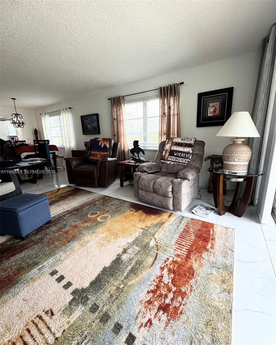 3776 Inverrary Boulevard, Unit 301R Lauderhill, FL 33319 - Photo 9 of 31 a living room with furniture and a flat screen tv