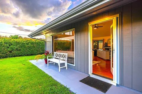 a porch with a bench next to a yard
