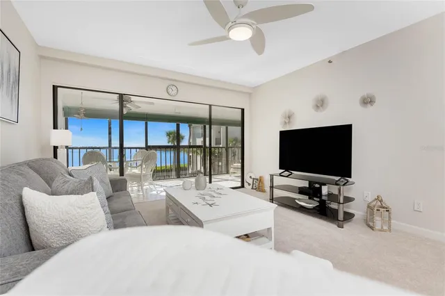 a living room with furniture a flat screen tv and a large window