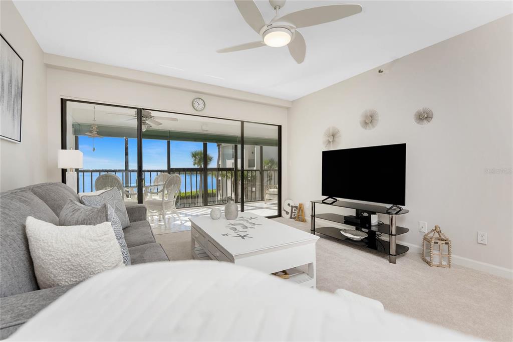 1551 Beach Road, Unit 306 Englewood, FL 34223 - Photo 15 of 50 a living room with furniture a flat screen tv and a large window