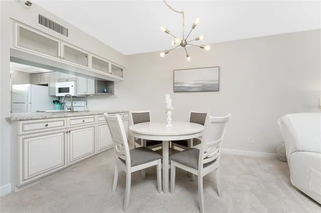 a kitchen with a dining table chairs and white cabinets