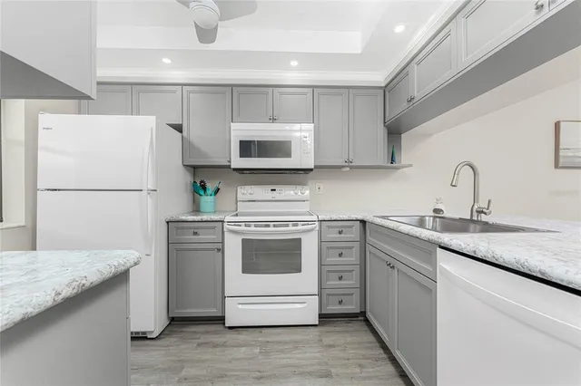 a kitchen with white cabinets and white appliances