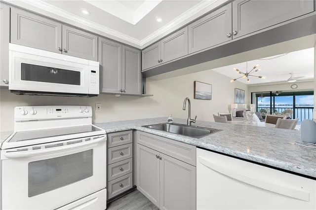 a kitchen with granite countertop white cabinets stainless steel appliances and a sink
