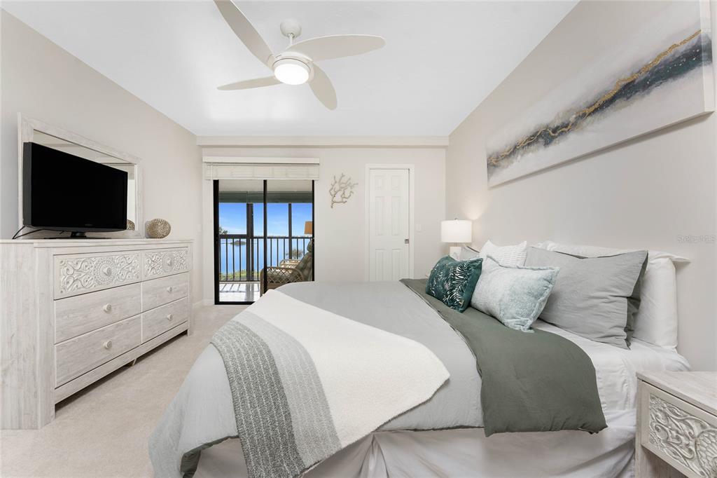 1551 Beach Road, Unit 306 Englewood, FL 34223 - Photo 24 of 50 a bedroom with a large bed and a flat screen tv