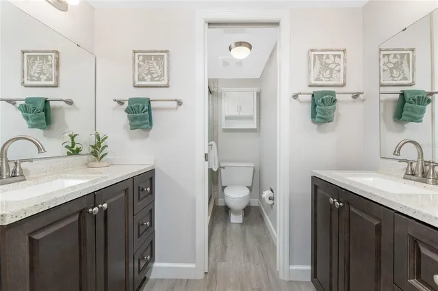 a bathroom with a granite countertop sink a toilet and a mirror