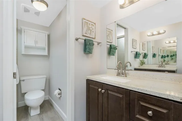 a bathroom with a granite countertop sink a toilet and a mirror