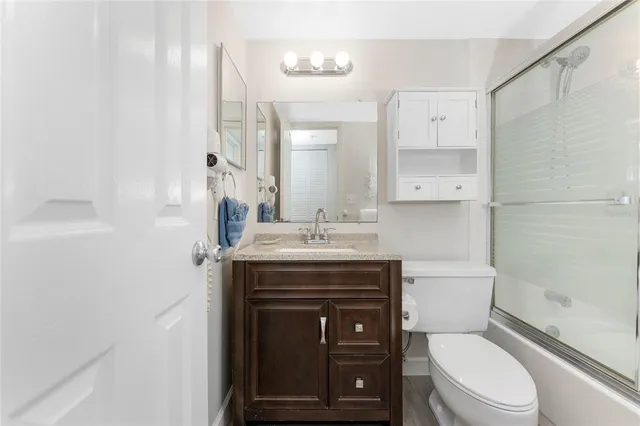 a bathroom with a granite countertop toilet sink and mirror
