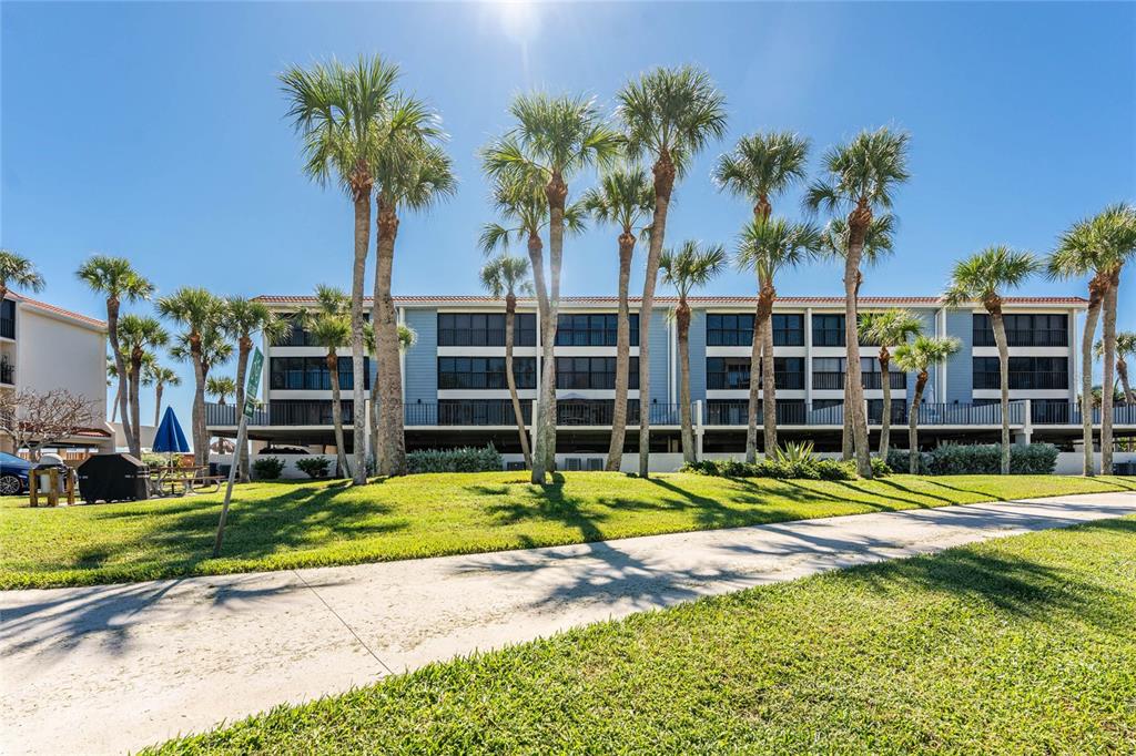 1551 Beach Road, Unit 306 Englewood, FL 34223 - Photo 49 of 50 a view of a swimming pool with a house and palm trees