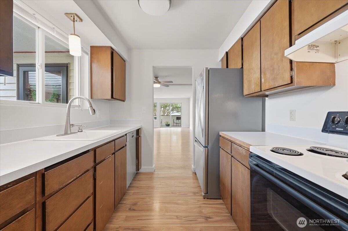 8516 196th Street Southwest, Unit 204 Edmonds, WA 98026 - Photo 7 of 16 a kitchen with a sink cabinets and stainless steel appliances