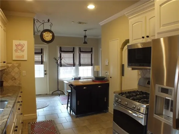 a kitchen with stainless steel appliances granite countertop a stove and a refrigerator