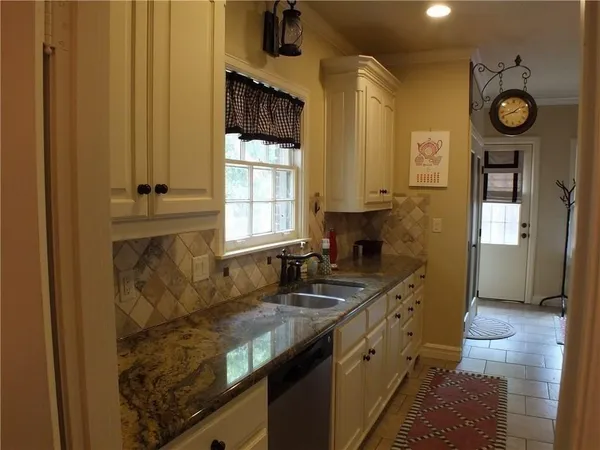 a kitchen with granite countertop a sink and a stove