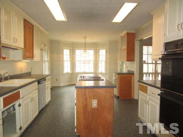 1307 Burlington Road Roxboro, NC 27573 - Photo 4 of 14 a kitchen with stainless steel appliances granite countertop a refrigerator a stove and a sink with cabinets