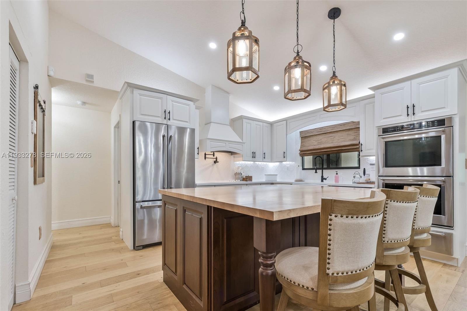 27260 Southwest 167th Court Homestead, FL 33031 - Photo 12 of 44 a kitchen with stainless steel appliances a dining table chairs microwave and cabinets