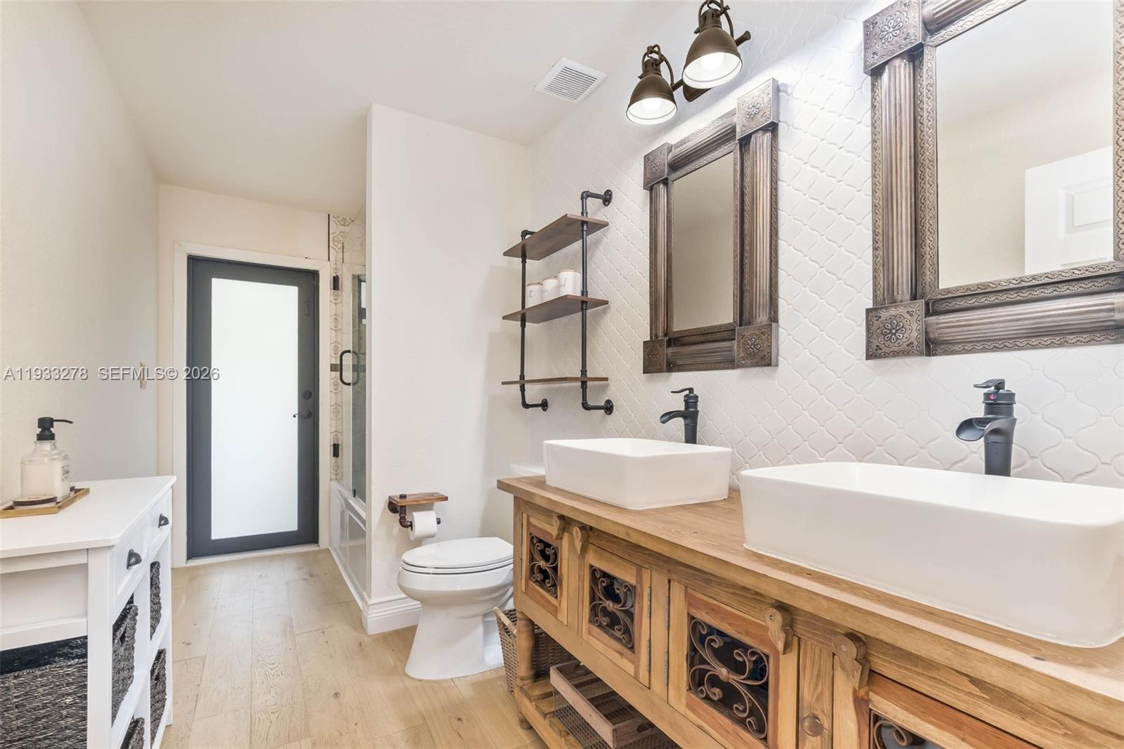 27260 Southwest 167th Court Homestead, FL 33031 - Photo 23 of 44 a bathroom with a double vanity sink mirror and toilet