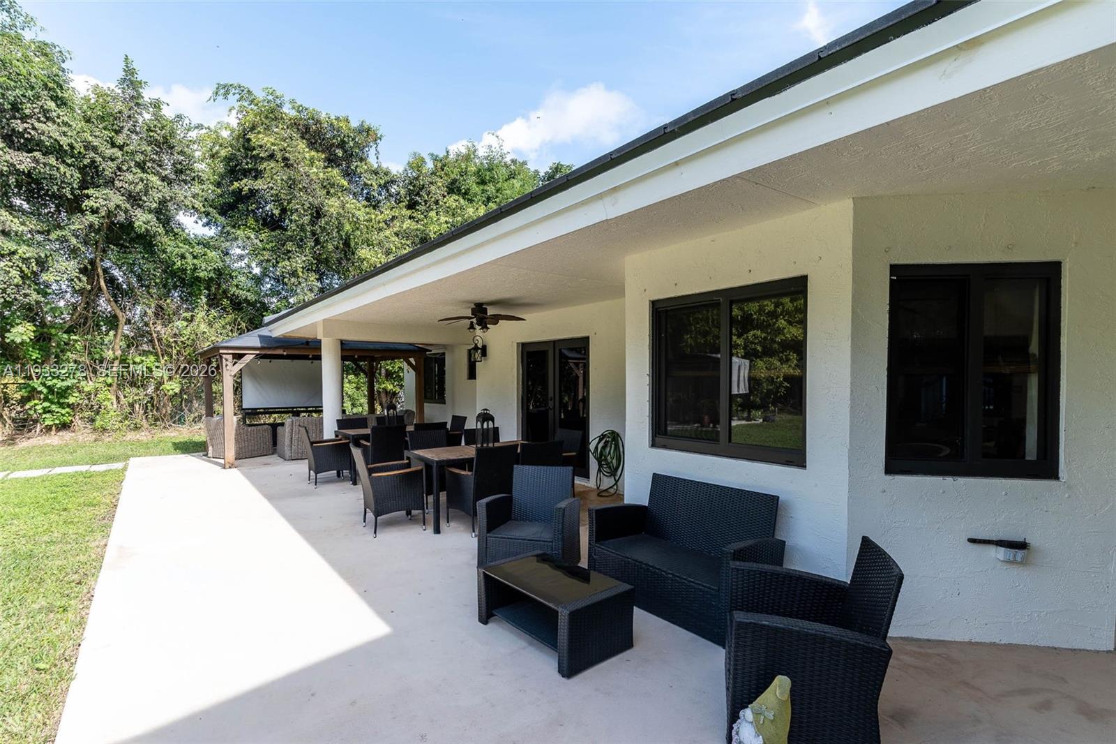 27260 Southwest 167th Court Homestead, FL 33031 - Photo 9 of 44 a view of a patio with couches table and chairs and potted plants