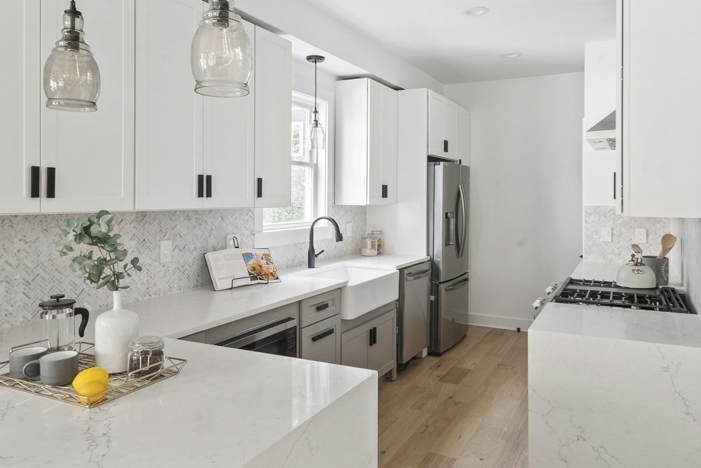 161 Lowell Street, Unit 1 Somerville, MA 02143 - Photo 5 of 18 a kitchen with stainless steel appliances a sink a stove and a refrigerator