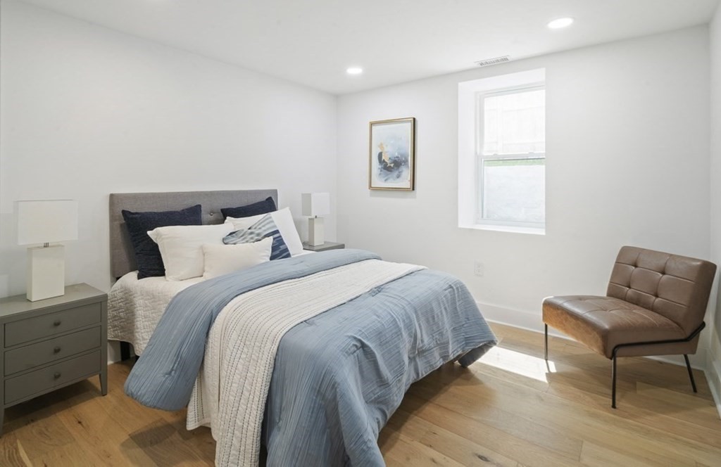 161 Lowell Street, Unit 1 Somerville, MA 02143 - Photo 9 of 18 a bedroom with a bed and chair