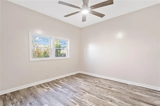 an empty room with a window and ceiling fan