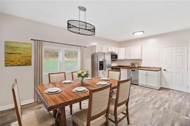 a view of a dining room with furniture a kitchen and chandelier