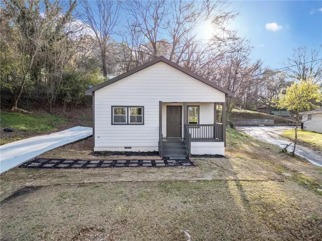 a view of a house with a yard and large tree