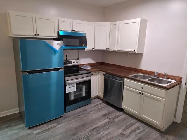 a kitchen with white cabinets and stainless steel appliances