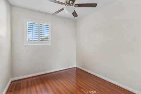 an empty room with a window and wooden floor