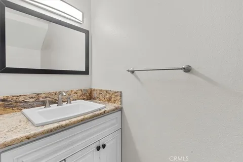 a bathroom with a granite countertop sink and mirror