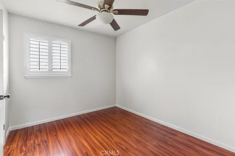 an empty room with a hardwood and windows